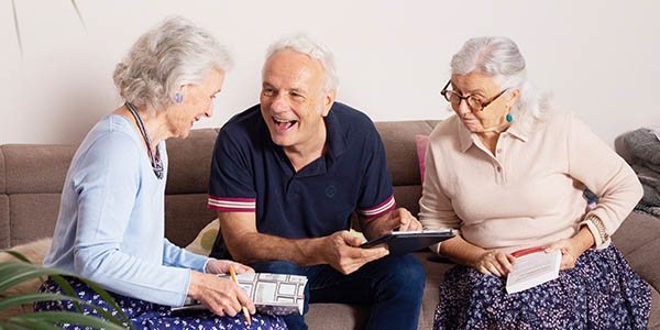 Trois résidents de la Maison des Sages partagent un moment autour d'une tablette